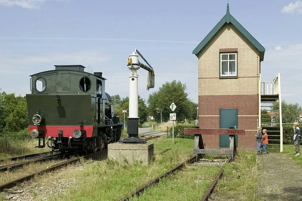 Hoedekenskerke: Locomotief bij het seinhuis met de watervulinstallatie van het station van Hoedekenskerke, gelegen aan het spoorbaantraject van de spoorwegremise in Goes naar Oudelande - Goes - 20396439 - RCE